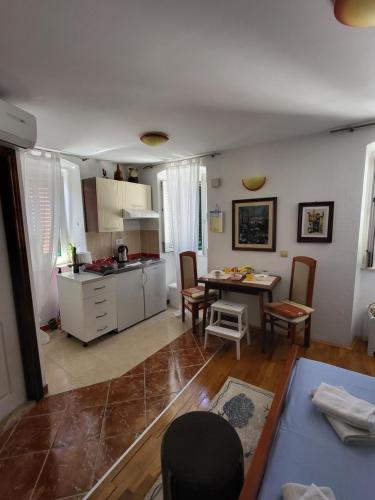 馬卡爾斯卡的住宿－studio Fani，厨房以及带桌椅的起居室。