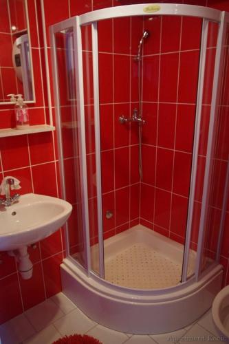 a red bathroom with a shower and a sink at studio Fani in Makarska