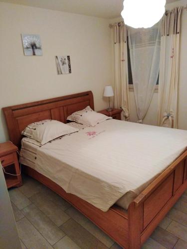 une chambre avec un grand lit avec des draps blancs dans l'établissement Maison accueillante à Nant avec piscine partagée, à Nant