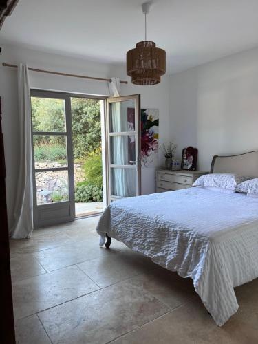 une chambre avec un lit et une porte coulissante en verre dans l'établissement Truffle and Oil, à Ventenac-Cabardès