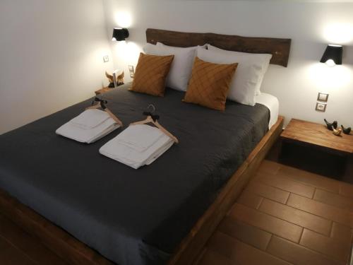 a bedroom with a large bed with two towels on it at REST SUITE On The Pedestrian Street in Kalavrita