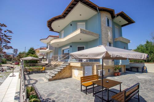 ein Gebäude mit Bänken und Tischen davor in der Unterkunft Milazio in Asprovalta