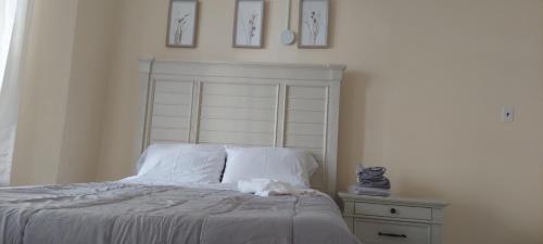 a bedroom with a bed with white sheets and a nightstand at Private Room in WNY,NJ 10 minutes from NYC #4 in West New York