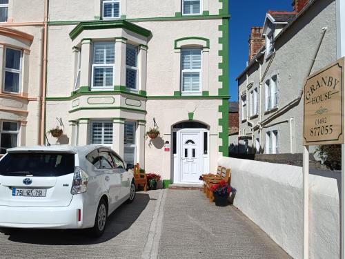 a white car parked in front of a house at Granby House in Llandudno