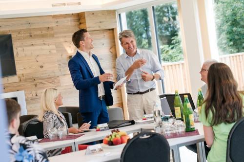a group of people sitting around a table in a meeting at R&R Residenzen HOTEL in Mitterbach