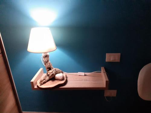 una lámpara en una pared con una iguana sentada en una cama en Casa Amy en San Michele Salentino