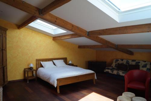 a bedroom with a bed and a couch and skylights at Chateau Le Livey in Saint-Pierre-dʼAurillac