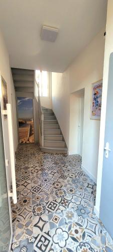 einen Flur mit einer Treppe und Fliesenboden in der Unterkunft Appartement studio 100m de la plage. in Berck-sur-Mer