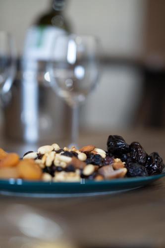 a plate of donuts on a table with a wine glass at Eidyllio Luxury Suites Omodos in Omodos