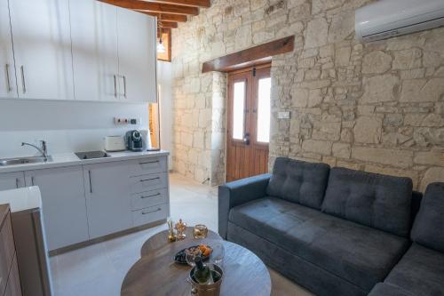 a kitchen and a living room with a couch and a table at Eidyllio Luxury Suites Omodos in Omodos