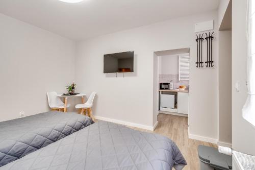 um quarto branco com uma cama e uma pequena mesa em Central Platinum Apartments 20 em Rybnik
