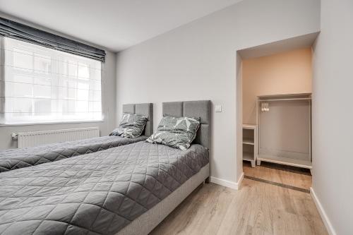 uma cama grande num quarto com uma janela grande em Central Platinum Apartments 20 em Rybnik
