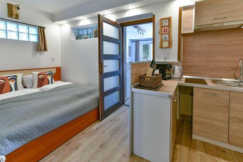 Il comprend une chambre avec un lit et une cuisine avec un évier. dans l'établissement Pitypang Apartman Felsőtárkány, à Felsőtárkány