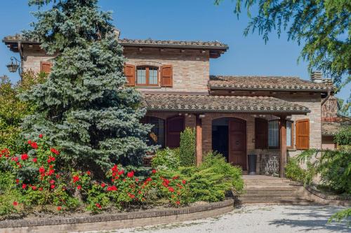 a house with red flowers in front of it at Villa Durante in Cagli