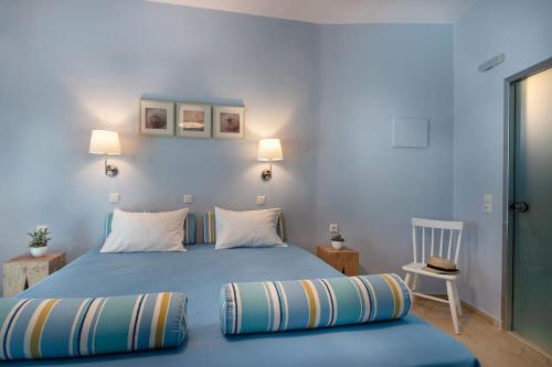 a bedroom with a blue bed with two pillows at Stella in the Village - Junior Studio Sea View in Plakias