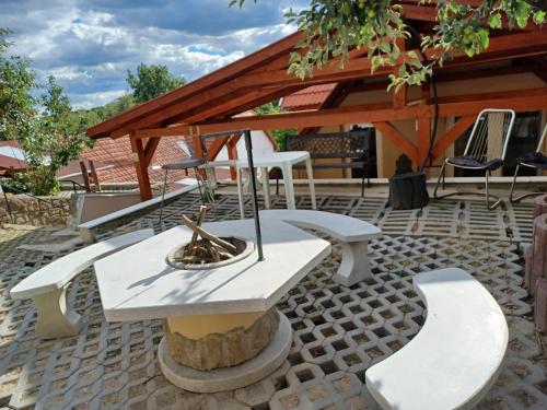 a picnic table and chairs on a patio at Bé-La Vendégház in Szomolya