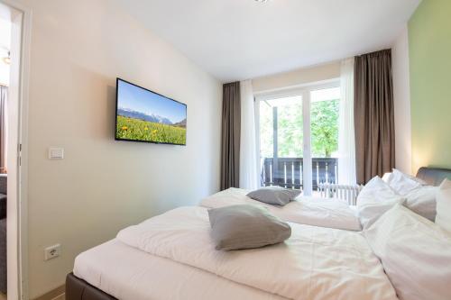 ガルミッシュ・パルテンキルヒェンにあるAlpennestのベッド2台 ホテルルーム 壁掛けテレビ付