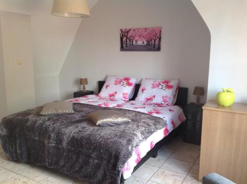 a bedroom with a bed with pink flowers on it at Holiday Home 't Beertje in Bruges