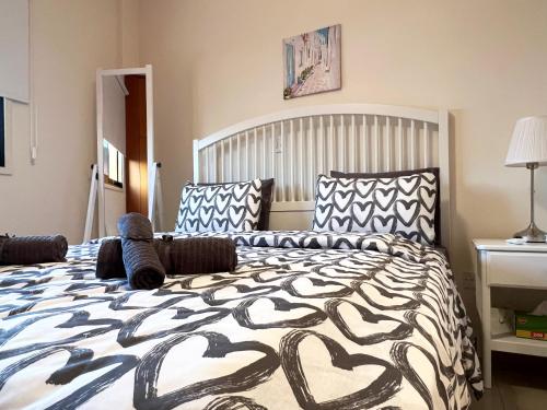 a bedroom with a large bed with a black and white comforter at Albert's apartment Centre 601 in Larnaca