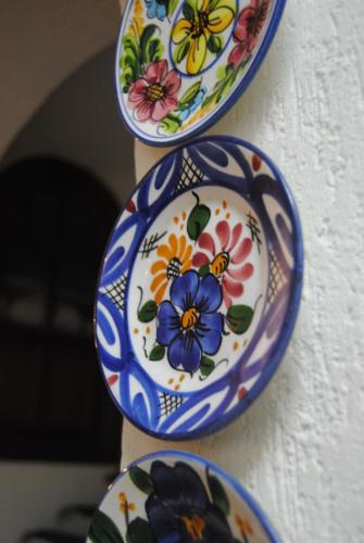 three plates with flowers on them hanging on a wall at Hostal Italia in Fuengirola