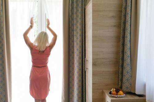 a woman is looking out of a window at R&R Residenzen HOTEL in Mitterbach