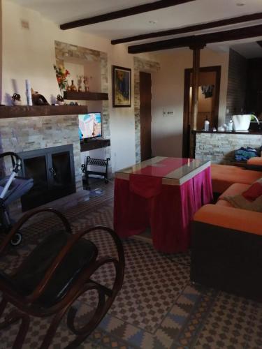 uma sala de estar com uma mesa e uma lareira em las palomas em Tózar