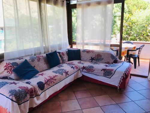 ein Sofa im Wohnzimmer mit Fenstern in der Unterkunft Mondello Aiace 40 in Mondello
