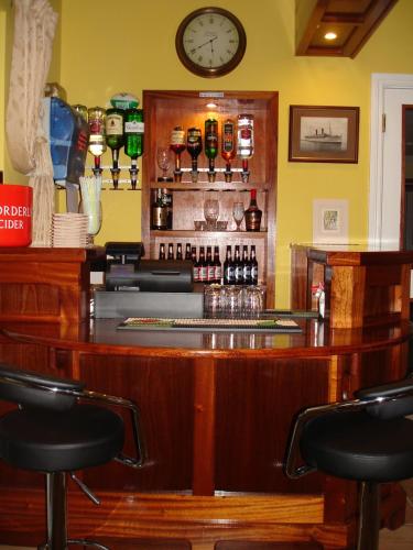 a bar with chairs and a clock on the wall at Seaview Guesthouse in Rostrevor