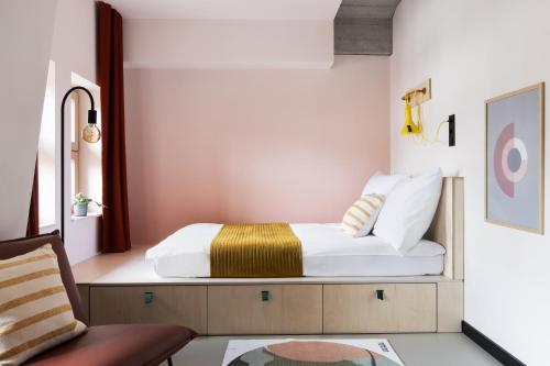sypialnia z łóżkiem i krzesłem w obiekcie Basecamp Wroclaw we Wrocławiu