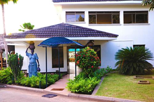 a house with a statue in front of it at Dolphin Suites in Kampala