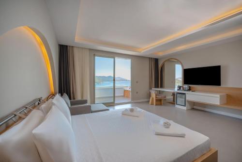 a hotel room with a bed and a flat screen tv at Kas Marin Hotel in Kaş