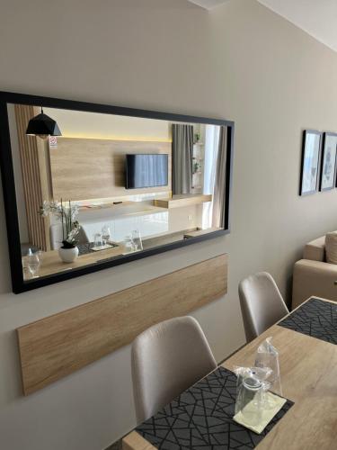 uma sala de jantar com um grande espelho na parede em Lux Hotel M em Dobra Voda