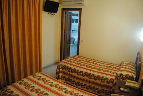 a hotel room with two beds and a window at Hostal Italia in Fuengirola