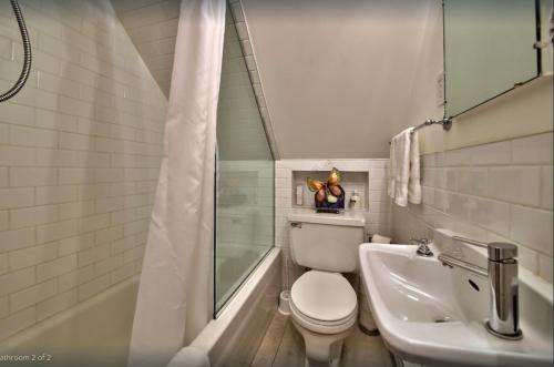 La salle de bains est pourvue de toilettes, d'une baignoire et d'un lavabo. dans l'établissement Les Maisons Montcalm, à Québec