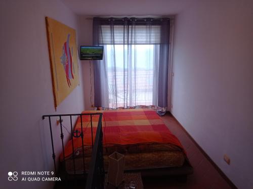 um pequeno quarto com uma cama e uma janela em EOS 17 em Palizzi Marina