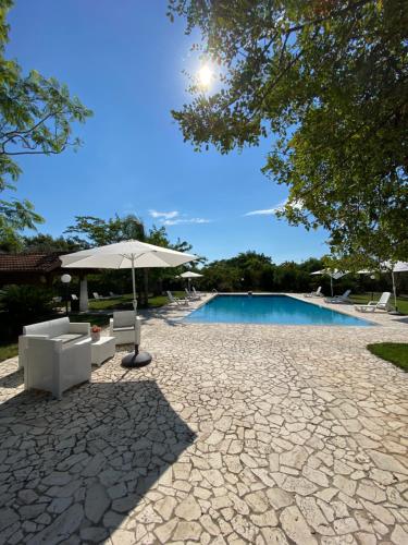 a patio with an umbrella and a swimming pool at Villa Paradiso in Latiano