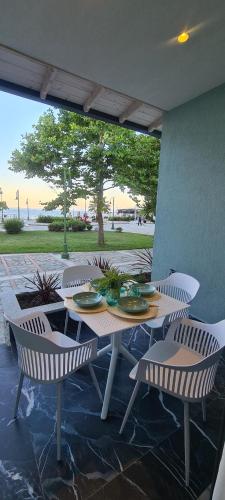 een tafel en stoelen op een patio bij Costa ANASTASIA_sea view suites in Nea Vrasna