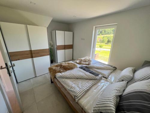 a bedroom with a bed and a window at Feriendomizil Schleich im Thermenland in Bad Gleichenberg