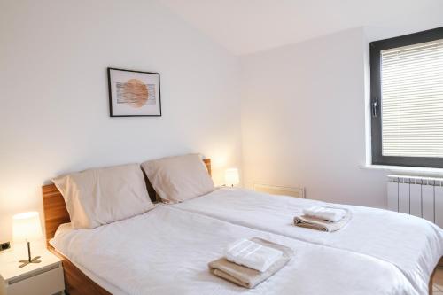 a bedroom with a white bed with two towels on it at Hiša Ivančič in Šared