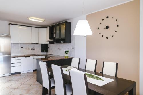a kitchen with a table and chairs and a clock on the wall at Hiša Ivančič in Šared