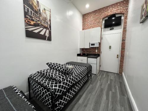 a small room with a bed and a kitchen at 31 Street Broadway Hotel in New York