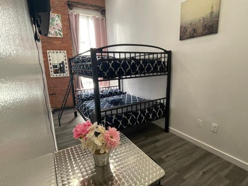 a room with bunk beds and a vase with flowers on a table at 31 Street Broadway Hotel in New York
