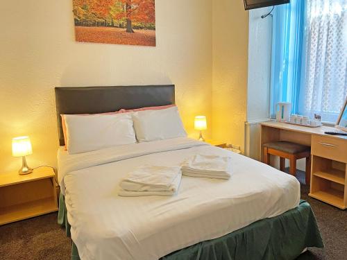 ein Schlafzimmer mit einem Bett mit zwei Handtüchern darauf in der Unterkunft Balin Helmshore in Blackpool
