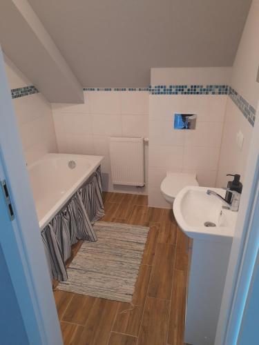 łazienka z umywalką, wanną i toaletą w obiekcie Agroturystyka Kruk w mieście Mirsk