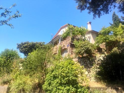 an old house on top of a hill with trees at Les Jardins d'Arbousse in Saint-Jean-du-Gard