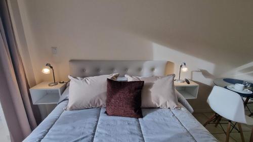 1 dormitorio con 1 cama con 2 mesas y 2 lámparas en La Esquina de Ramayon - Andarlibre en San Martín de los Andes