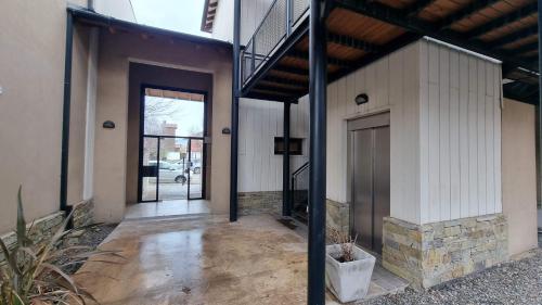 una entrada a un edificio con puerta y porche en La Esquina de Ramayon - Andarlibre en San Martín de los Andes