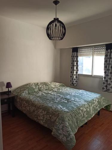 a bedroom with a bed and a pendant light at HERMOSO DEPARTAMENTO in Rosario