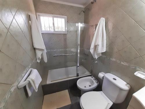 a bathroom with a toilet and a shower and a sink at Departamento Las Margaritas in Potrero de los Funes
