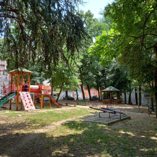 a park with a playground with slides and a tree at Rivijera in Belgrade